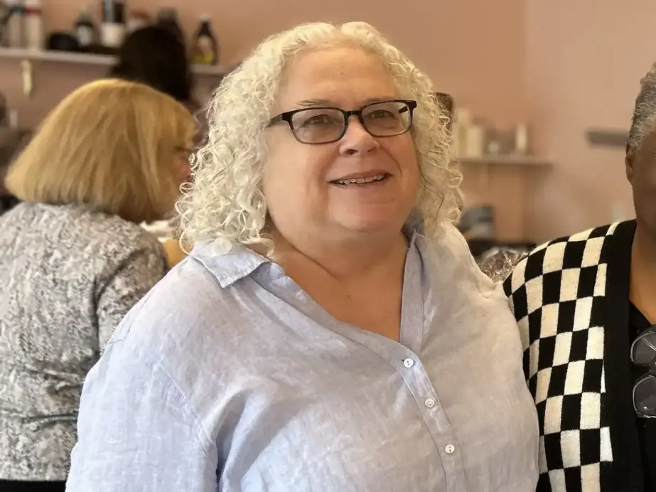 Cate Salk indoors with curly white hair and glasses